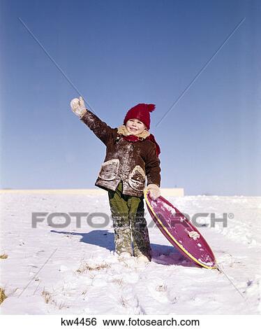 1970S Little Boy Holding Snow Saucer Type Toboggan And Waving Sled Fun Plastic Round View Large Photo Image Stock Photograph - 1970S Little Boy Holding Snow Saucer Type Toboggan And Waving Sled Fun Plastic Round. Fotosearch