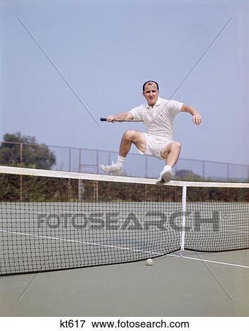1970S Middle Aged Man Jumping Over Net On Tennis Court Balding Fitness Agile Wellness Lifestyle View Large Photo Image Stock Photo - 1970S Middle Aged Man Jumping Over Net On Tennis Court Balding Fitness Agile Wellness Lifestyle. Fotosearch