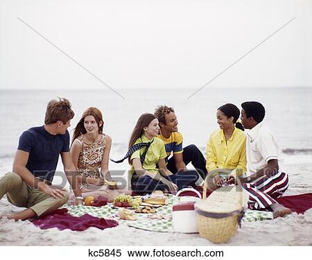 1970S Mixed Ethnic Group Teenage Couples Picnic On Beach African-American Couple View Large Photo Image Stock Photography - 1970S Mixed Ethnic Group Teenage Couples Picnic On Beach African-American Couple . Fotosearch