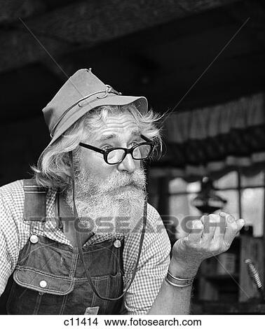 1970S Older Man Hillbilly Character Wearing Cloth Hat Overalls Gingham Shirt With Glasses Beard Outdoor View Large Photo Image Picture - 1970S Older Man Hillbilly Character Wearing Cloth Hat Overalls Gingham Shirt With Glasses Beard Outdoor . Fotosearch