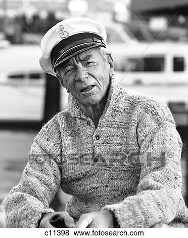 1970S Older Man In Fisherman'S Hat Sweater Holding Pipe Sitting On Docks Outdoor View Large Photo Image Stock Photo - 1970S Older Man In Fisherman'S Hat Sweater Holding Pipe Sitting On Docks Outdoor . Fotosearch