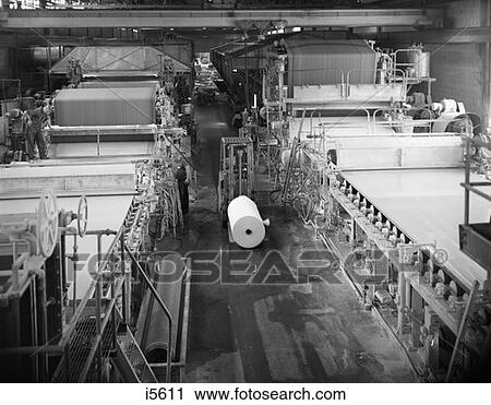 Stock Image - 1970S Partial Overhead Looking Down Aisle Of Paper Factory With Large Rollers To Either Side . Fotosearch