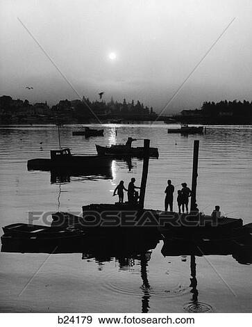 1970S People Fishing Off Of Dock With With Small Boats In Background At Dusk View Large Photo Image Stock Photo - 1970S People Fishing Off Of Dock With With Small Boats In Background At Dusk . Fotosearch