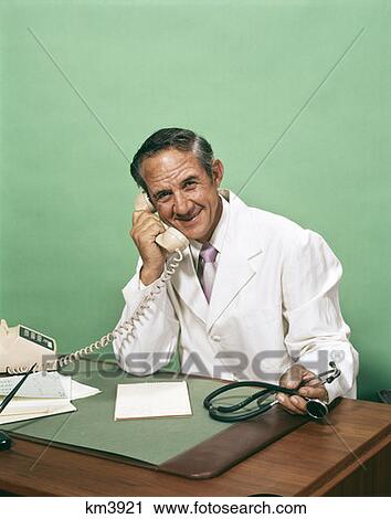 1970S Portrait Doctor Physician Desk Talking Telephone Smiling Hold Stethoscope  View Large Photo Image Stock Image - 1970S Portrait Doctor Physician Desk Talking Telephone Smiling Hold Stethoscope . Fotosearch