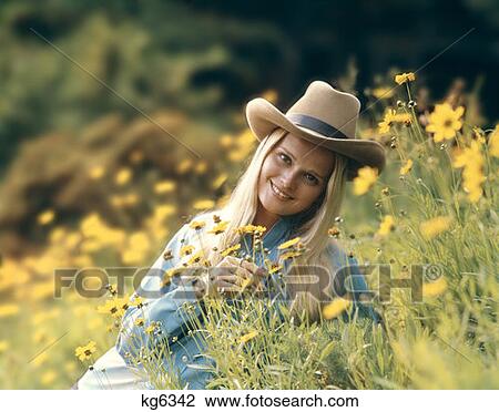 1970S Retro Blond Woman Wearing Cowboy Hat Sitting In A Field Of Buttercup Wild Flowers Smiling View Large Photo Image Stock Image - 1970S Retro Blond Woman Wearing Cowboy Hat Sitting In A Field Of Buttercup Wild Flowers Smiling. Fotosearch