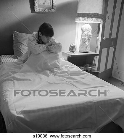1970S Sad Lonely Serious Woman Sitting Up In Bed Arms Around Knees Insomnia Sleepless Worried View Large Photo Image Stock Photograph - 1970S Sad Lonely Serious Woman Sitting Up In Bed Arms Around Knees Insomnia Sleepless Worried . Fotosearch