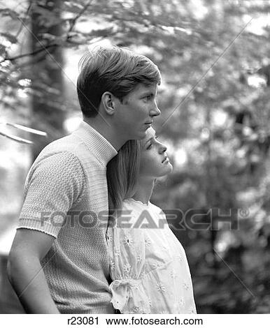 1970S Side View Of Couple Standing In Woods Woman Leaning Back Against Man View Large Photo Image Stock Image - 1970S Side View Of Couple Standing In Woods Woman Leaning Back Against Man . Fotosearch