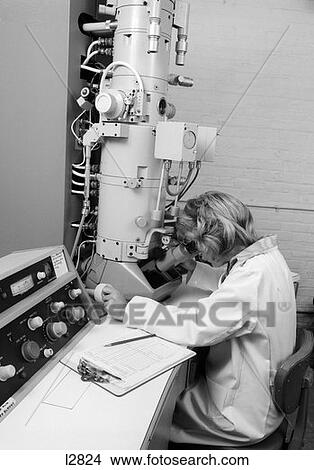 1970S Side View Of Woman In Lab Coat Looking Through Electron Microscope View Large Photo Image Picture - 1970S Side View Of Woman In Lab Coat Looking Through Electron Microscope . Fotosearch