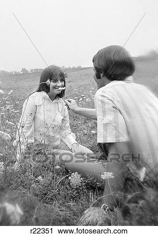 1970S Soft-Focus Shot Of Couple Sitting In Field Man Holding Queen Anne'S Lace Up To Woman'S Face View Large Photo Image Stock Image - 1970S Soft-Focus Shot Of Couple Sitting In Field Man Holding Queen Anne'S Lace Up To Woman'S Face . Fotosearch