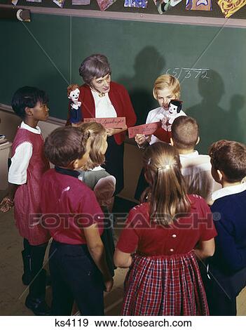 1970S Teacher And Student Showing Hand Puppets To Classmates Gathered Around Them View Large Photo Image Stock Photo - 1970S Teacher And Student Showing Hand Puppets To Classmates Gathered Around Them. Fotosearch