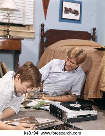1970S Two Teen Boys Portable Record Player Listening To Music Records In Bedroom Dorm Room Dormitory View Large Photo Image Picture - 1970S Two Teen Boys Portable Record Player Listening To Music Records In Bedroom Dorm Room Dormitory . Fotosearch