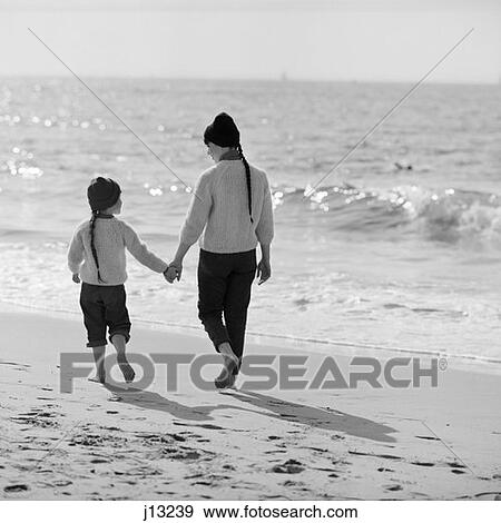 1970S Woman Girl Mother Daughter Walking Along Surf Beach Ocean Backs To Camera Holding Hands Talking View Large Photo Image Stock Photo - 1970S Woman Girl Mother Daughter Walking Along Surf Beach Ocean Backs To Camera Holding Hands Talking. Fotosearch