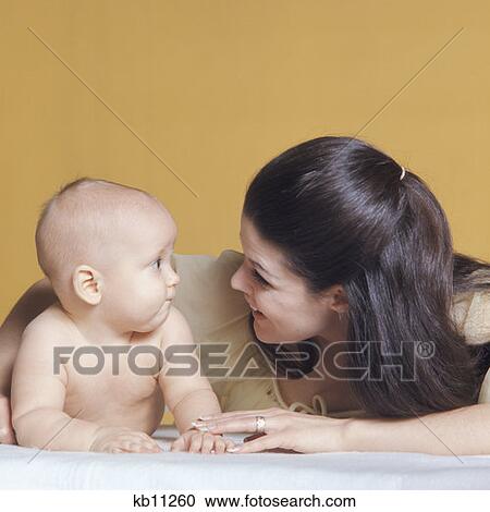 1970S Woman Mother And Cute Infant Baby Looking Face To Face Surprise View Large Photo Image Stock Image - 1970S Woman Mother And Cute Infant Baby Looking Face To Face Surprise. Fotosearch
