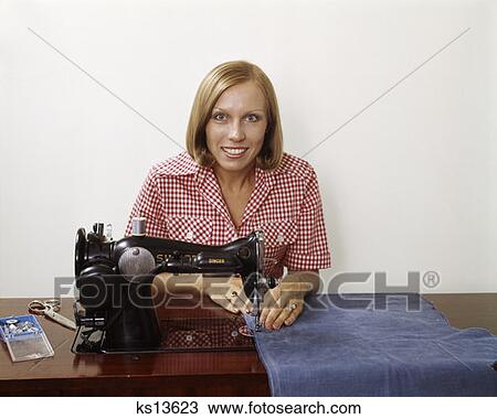 1970S Woman Operating Sewing Machine Household Appliance Sew Skill Craft Housewife Wearing Checked Blouse View Large Photo Image Stock Image - 1970S Woman Operating Sewing Machine Household Appliance Sew Skill Craft Housewife Wearing Checked Blouse . Fotosearch