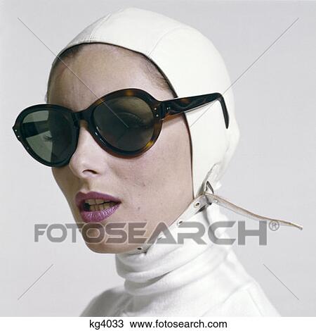 1970S Woman Portrait White Turtle Neck White Strap Aviator Helmet Hat Wearing Large Tortoise Shell Sunglasses Fashion View Large Photo Image Stock Image - 1970S Woman Portrait White Turtle Neck White Strap Aviator Helmet Hat Wearing Large Tortoise Shell Sunglasses Fashion. Fotosearch