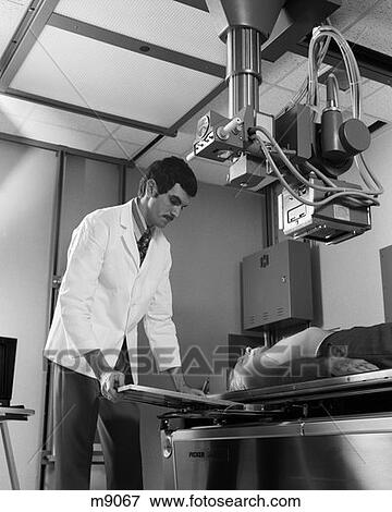 1970S X-Ray Technician X-Raying A Patient With A Cat Scanner Inside The X-Ray Department In Hospital View Large Photo Image Stock Photo - 1970S X-Ray Technician X-Raying A Patient With A Cat Scanner Inside The X-Ray Department In Hospital . Fotosearch