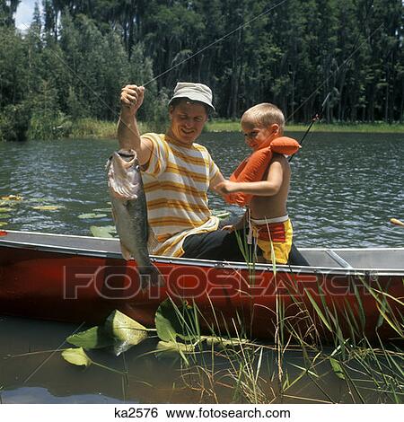 1980 1980S Father & Son In Canoe Holding Up Catch Fish Lake Boy Life Preserver Fishing Man Men Family Activity Retro View Large Photo Image Stock Photograph - 1980 1980S Father & Son In Canoe Holding Up Catch Fish Lake Boy Life Preserver Fishing Man Men Family Activity Retro. Fotosearch