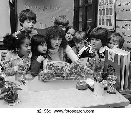 1980S Teacher Reading Book To Group Of Grade School Students Gathered Around Her View Large Photo Image Stock Photography - 1980S Teacher Reading Book To Group Of Grade School Students Gathered Around Her . Fotosearch