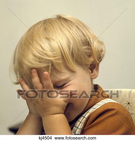 Picture - 20 Month Old Boy With Blonde Hair Hiding Behind Hands Playing Peek A Boo. Fotosearch