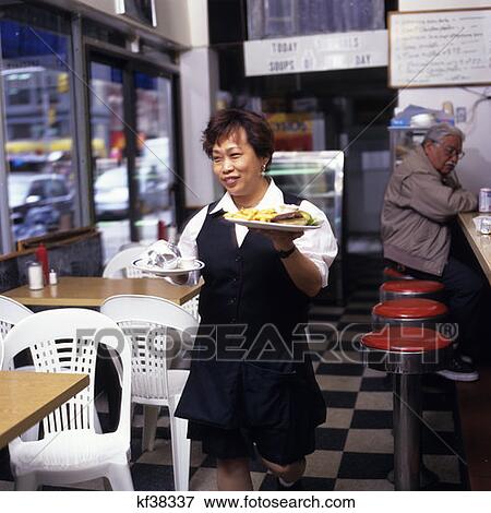 Asian Waitress In Diner Bringing Food To Customer View Large Photo Image Stock Photo - Asian Waitress In Diner Bringing Food To Customer. Fotosearch