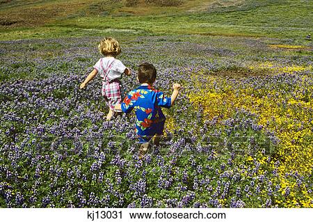 Stock Image - Boy And Girl Walking Through Flowers . Fotosearch