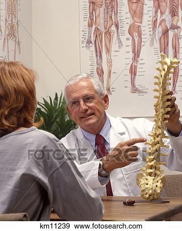 Stock Photo - Chiropractor With Woman Patient In Office . Fotosearch