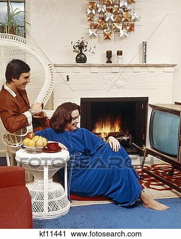 Couple In Living Room Sitting In Front Of Television And Beside A Fire View Large Photo Image Stock Image - Couple In Living Room Sitting In Front Of Television And Beside A Fire. Fotosearch