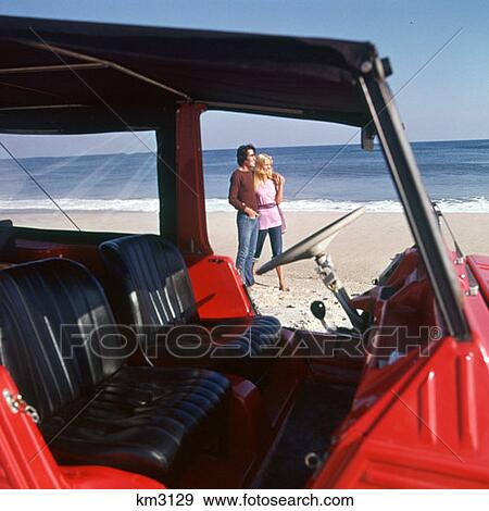 Couple On Beach Standing Outside Vehicle View Large Photo Image Stock Photo - Couple On Beach Standing Outside Vehicle. Fotosearch