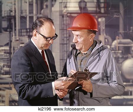 Executive And Engineer With Clipboard Talking Factory Refinery In Background Outdoor Hard Hat View Large Photo Image Stock Photograph - Executive And Engineer With Clipboard Talking Factory Refinery In Background Outdoor Hard Hat. Fotosearch