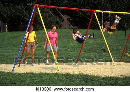 Stock Image - Family Playing On Swing Set Not Available For Pocono Resort Usages . Fotosearch