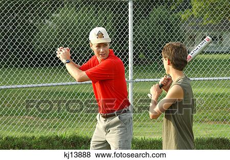 Stock Photo - Father Teaching Son Batting In Baseball. Fotosearch