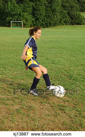 Stock Photo - Girl Soccer Player Kicking Soccer Ball. Fotosearch