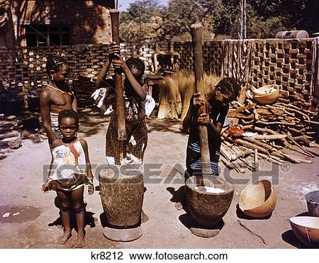Stock Image - Grinding Millet Mortar Pestle Primitive Farming Methods Third World Mali, Africa. Fotosearch