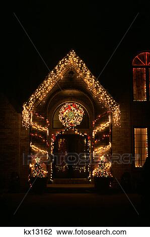 House Doorway Decorated With Wreath And Christmas Lights Stock