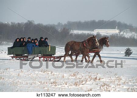 Stock Photo - Lancaster Pennsylvania Amish Family Riding In Horse Drawn Sled Wagon In Winter . Fotosearch