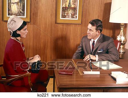 Man Interviewing Woman At Desk In Office Indoor Business Interview Meeting 1960 1960S View Large Photo Image Stock Image - Man Interviewing Woman At Desk In Office Indoor Business Interview Meeting 1960 1960S . Fotosearch