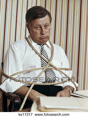 Man Office Tied Ropes Portrait 1974 1970S Retro View Large Photo Image Stock Photo - Man Office Tied Ropes Portrait 1974 1970S Retro. Fotosearch
