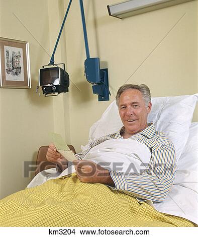 Picture - Man Patient In Hospital Bed Opening Mail Retro 1970 1970S. Fotosearch
