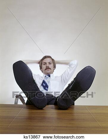 Man Sitting Office Desk Feet Up Relaxing Mustache 1970 1970S Retro View Large Photo Image Stock Photo - Man Sitting Office Desk Feet Up Relaxing Mustache 1970 1970S Retro. Fotosearch