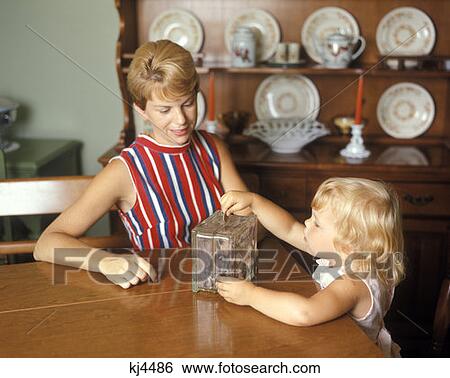 Mother And Daughter Piggy Bank Glass Block Dining Room 1970 1970S Retro View Large Photo Image Stock Photograph - Mother And Daughter Piggy Bank Glass Block Dining Room 1970 1970S Retro . Fotosearch