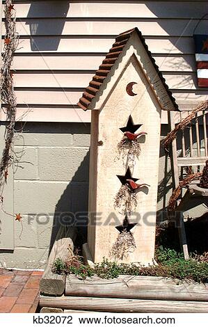 Stock Image - Narrow Birdhouse With Tin Roof And Star Cutouts . Fotosearch