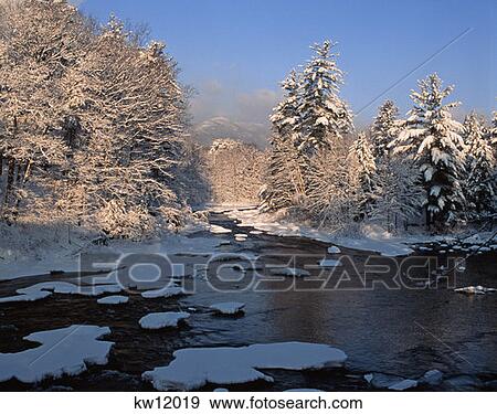 Stock Photo - Partially Frozen Lake And Snow Covered Trees Conway New Hampshire . Fotosearch