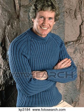 Picture - Portrait Of Man With Blonde Hair, Blue Sweater And Beige Pants. Fotosearch