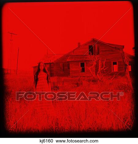 Stock Image - Red Image Of Teenage Girl Standing Outside Abandoned Barn. Fotosearch