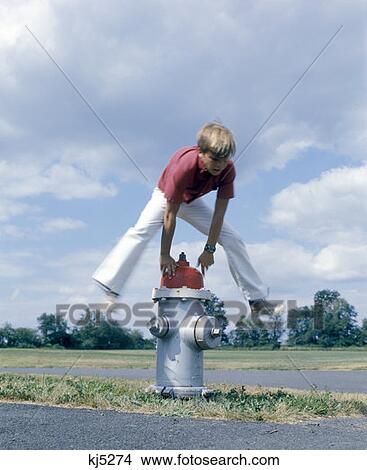 Retro 1970 1970S Boy Jumping Over Fire Hydrant View Large Photo Image Picture - Retro 1970 1970S Boy Jumping Over Fire Hydrant. Fotosearch