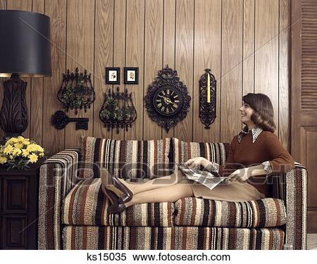 Retro 1970 1970S Woman Sitting On Striped Couch With Feet Up Looking Up Holding Magazine View Large Photo Image Stock Photography - Retro 1970 1970S Woman Sitting On Striped Couch With Feet Up Looking Up Holding Magazine. Fotosearch