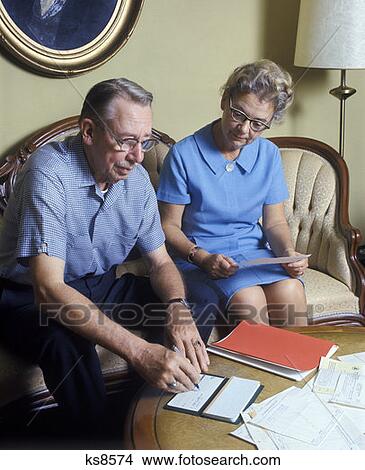 Retro Elderly Couple 1970 1970S Paying Bills View Large Photo Image Picture - Retro Elderly Couple 1970 1970S Paying Bills. Fotosearch