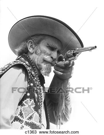 Senior Bearded Cowboy Pointing A Revolver At The Camera Dressed In Fringed Glove Beaded Vest Wide Brimmed Hat View Large Photo Image Stock Image - Senior Bearded Cowboy Pointing A Revolver At The Camera Dressed In Fringed Glove Beaded Vest Wide Brimmed Hat . Fotosearch