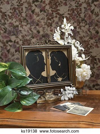 Silhouette Of Man And Woman Profile Portrait In Picture Frame Old Photographs Plants On Table View Large Photo Image Stock Photo - Silhouette Of Man And Woman Profile Portrait In Picture Frame Old Photographs Plants On Table. Fotosearch
