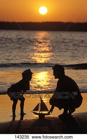 Silhouetted Father And Son With Toy Boat At The Beach View Large Photo Image Stock Photography - Silhouetted Father And Son With Toy Boat At The Beach . Fotosearch